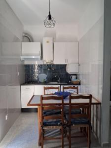 a kitchen with a wooden table with chairs and a sink at Apartamento azul Mar in Albufeira
