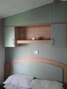 a bedroom with a bed with a wooden headboard at The Retreat at Marine Holiday Park in Rhyl +17 photos