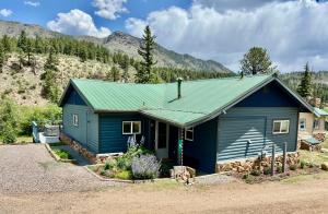 a blue house with a green roof at Riverfront Cabin W Deck & Seasonal Pool in Shawnee