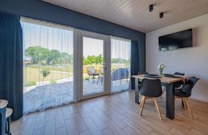 a dining room with a table and a sliding glass door at Porzeczkowe domki in Darłowo +39 photos