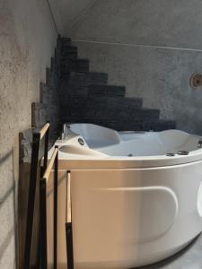 a white tub in a bathroom with a brick wall at Chata Drwala w Rynku -Duża Wanna -Klima ,1-4 Os -Car Park Faktura in Kielce +26 photos