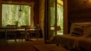 a room with a bed and a table and a window at Biały Las Magiczna Stara Chata Puszcza Białowieska in Starzyna