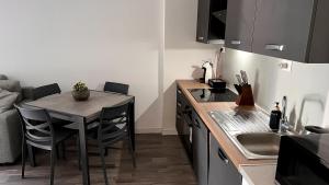 a small kitchen with a table and a kitchen with a sink at Cosy&Chic Le Betulle-Malpensa MXP in Gallarate