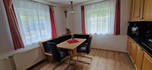 a small kitchen with a table and chairs and windows at Steiner`s Ferienwohnung in Winklern