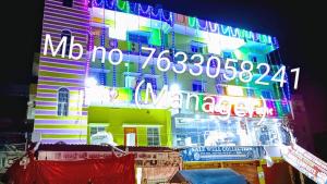 a building with a neon sign on the side of it at Hotel DEEPAK PALACE in Gaya