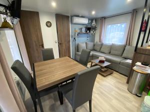 ein Wohnzimmer mit Tisch und Couch in der Unterkunft Douce Escale in Lège-Cap-Ferret