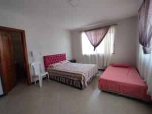 ein Schlafzimmer mit zwei Betten und einem Fenster in der Unterkunft Casa General Villamil, amplia y cerca del mar in Playas