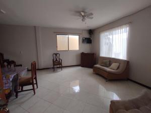 ein Wohnzimmer mit einer Couch und einem Tisch und Stühlen in der Unterkunft Casa General Villamil, amplia y cerca del mar in Playas