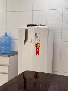 a white refrigerator with stickers on it in a kitchen at Nox Temporada Flat 201 com AR, a 5 Min da Feira de Caruaru in Caruaru