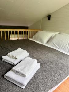 a bedroom with two beds with white towels on the bed at Private mini-villa retreat in nature in Penu