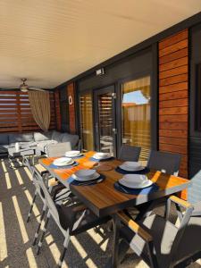 a dining room with a wooden table and chairs at Mobile home Privlaka in Privlaka