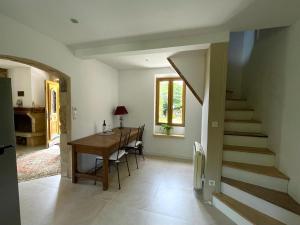 a kitchen and dining room with a table and a staircase at Le Cottage dans la Vallée des 5 châteaux in Vézac