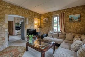 a living room with a couch and a table at Le Cottage dans la Vallée des 5 châteaux in Vézac