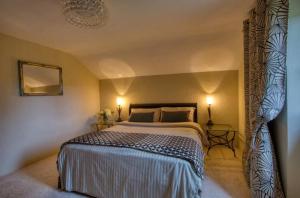 a bedroom with a large bed and two lamps at Le Cottage dans la Vallée des 5 châteaux in Vézac