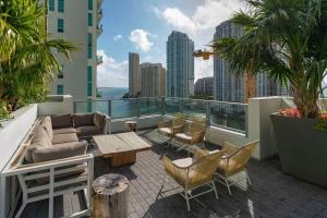 a rooftop patio with furniture and a view of the city at Brickell LuxePad 1BED 1BATH with Pool, Gym, Sauna, Grills, Cinema Projector in Miami