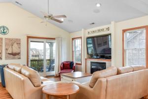 a living room with two couches and a tv at Curlews Call in Nags Head
