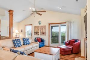a living room with a couch and two chairs at Curlews Call in Nags Head