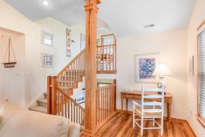 a room with a staircase and a desk with a chair at Curlews Call in Nags Head +29 photos