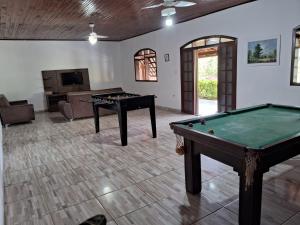 a living room with a pool table and a couch at Chácara Curuco in Mairinque