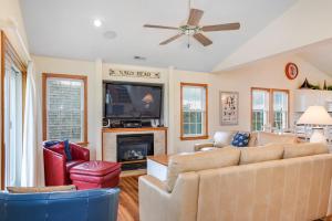 a living room with a couch and a tv at Curlews Call in Nags Head