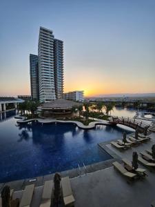 a large swimming pool in a city with tall buildings at Grand Sapphire Casino studio 20 in Iskele