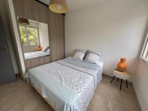 a small bedroom with a bed and a mirror at Appartement 3 pièces à 5 min de la plage in La Seyne-sur-Mer