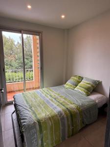 a bedroom with a bed and a large window at Appartement 3 pièces à 5 min de la plage in La Seyne-sur-Mer