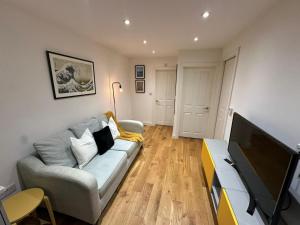 a living room with a couch and a flat screen tv at The Hideaway Haven in Belvedere