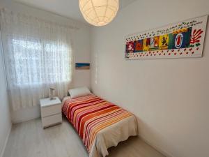 a small bedroom with a bed and a window at Apartamento Celine in Pineda de Mar