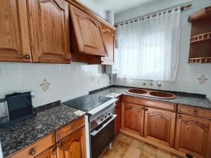a kitchen with wooden cabinets and a stove top oven at Apartamento Celine in Pineda de Mar