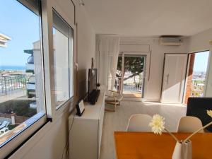a living room with a table and a large window at Apartamento Celine in Pineda de Mar