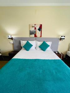 a bedroom with a large bed with a blue blanket at Hotel Colmeia in Monte Real