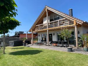 a house with a deck and a patio at Landliebe, Ferienhaus, 3 Schlafzimmer mit Sauna und Outdoor Whirlpool in Geierswalde