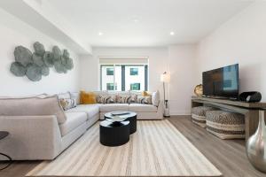 a living room with a couch and a tv at Brand NEW Townhome! Luxury AND Convenience - NO EXTRA FEES! in Grand Junction