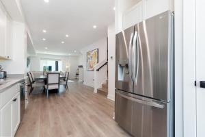 a kitchen and dining room with a stainless steel refrigerator at Brand NEW Townhome! Luxury AND Convenience - NO EXTRA FEES! in Grand Junction
