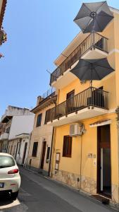a yellow building with an umbrella on a street at Casa vacanza Stella in Torre Forte