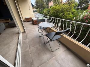 a patio with a table and chairs on a balcony at Appartement 3 pièces à 5 min de la plage in La Seyne-sur-Mer