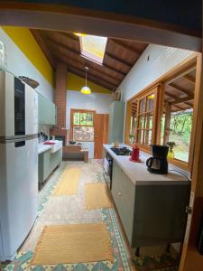 a kitchen with a refrigerator and a counter top at Yellow House Santa Clara in Bocaina de Minas
