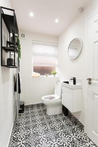 a white bathroom with a toilet and a sink at The Belfast Snug in Belfast