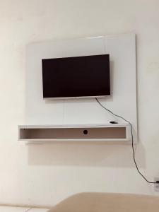 ein Flachbildfernseher, der an einer Wand hängt in der Unterkunft Nox Temporada Flat 301 com AR, a 5 Min da Feira de Caruaru in Caruaru