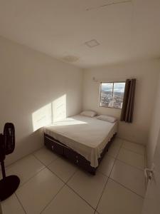 ein weißes Schlafzimmer mit einem Bett und einem Fenster in der Unterkunft Nox Temporada Flat 301 com AR, a 5 Min da Feira de Caruaru in Caruaru + 15 Fotos