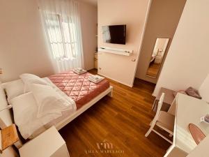 a small bedroom with a bed and a television at Villa Marelago Guest House in Lido Di Fondi