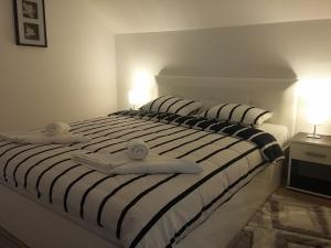 a white bed with two towels on top of it at Apartment Rosandić in Smoljanac