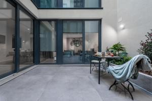 un patio con porte in vetro, tavolo e sedie di SuitePrince a Torino