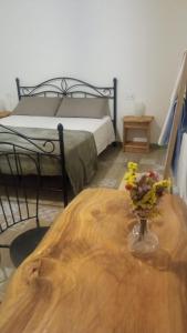 a bedroom with a bed and a wooden table with flowers on it at La grande quercia 