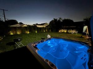 a blue hot tub in a yard at night at LUXURY VILLA Estate Oasis in Downey