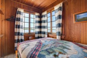 a bedroom with a bed and two windows at Fish, Boat and Swim Cedarville Gem 6 with Dock Access in Cedarville