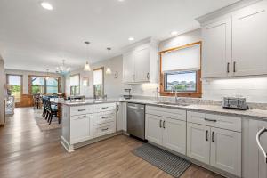 a kitchen with white cabinets and a dining room at Endless Summer in Sanderling