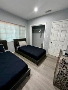 a bedroom with two beds and a white door at LUXURY VILLA Estate Oasis in Downey +64 photos