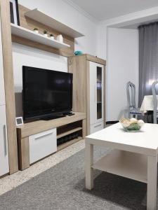 ein Wohnzimmer mit einem Flachbildfernseher auf einem Entertainment-Center in der Unterkunft Piso céntrico cerca de la playa Cedeira in Cedeira